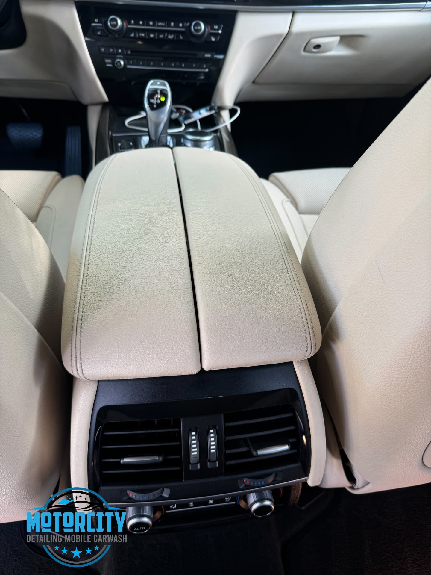 Beige leather armrest and rear vents after interior detailing