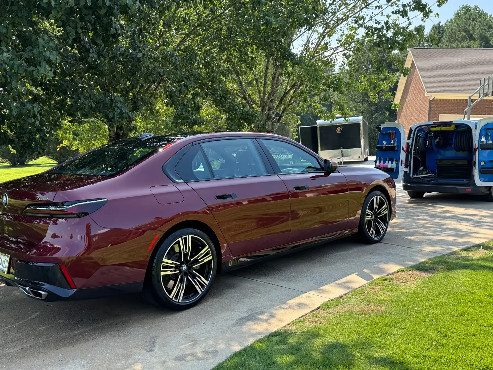 Mobile car detailing on a maroon BMW 760i sedan in a driveway