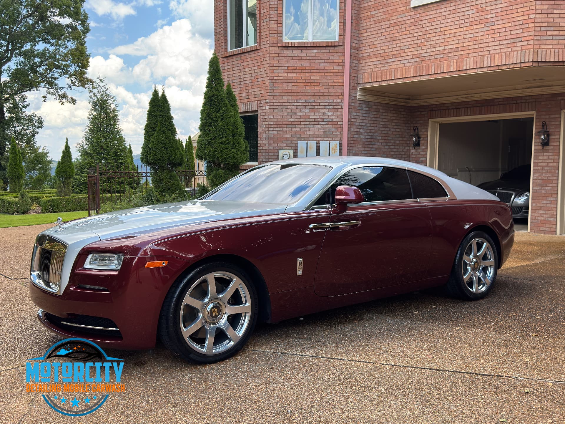 Two-tone maroon and silver Rolls-Royce Wraith detailed in a driveway