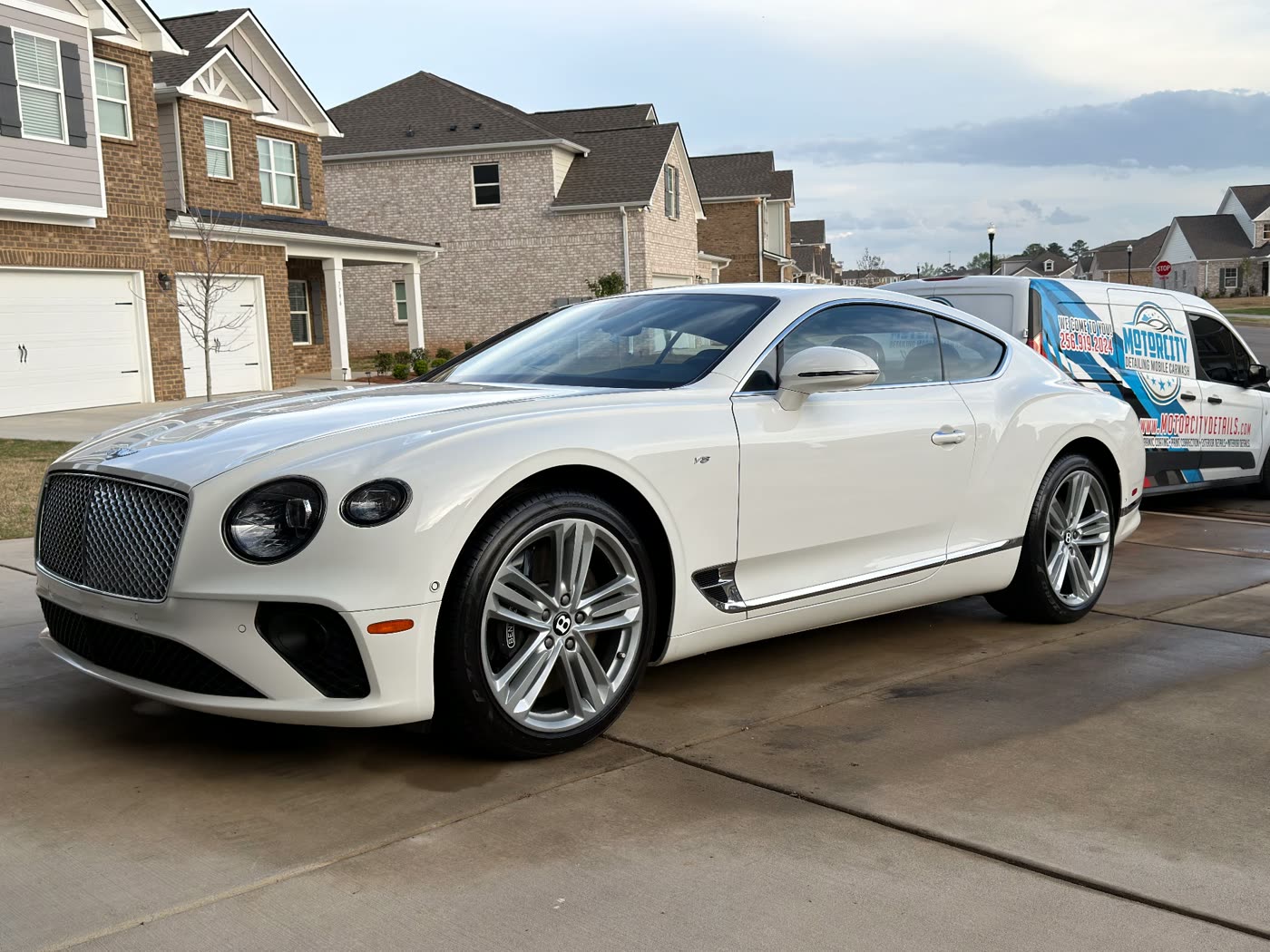 White Bentley detailed in a Franklin, TN driveway beside the Motorcity Detailing mobile unit